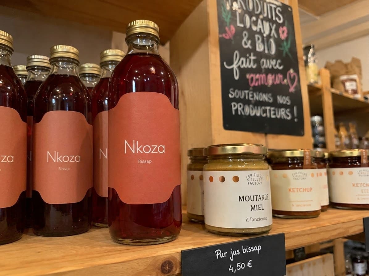 Bouteilles de jus et bocaux de moutarde et de ketchup en rayon, habillés d'étiquettes imprimées en couleur